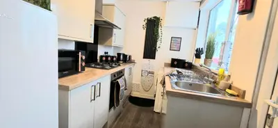 a kitchen with a sink and a stove top oven at Comfortable 3BR - Sleeps 5 - Fast WiFi -Parking in Barrow in Furness