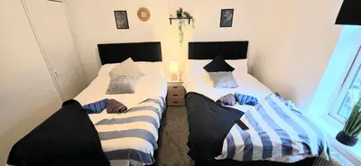 two twin beds in a bedroom withskirts at Comfortable 3BR - Sleeps 5 - Fast WiFi -Parking in Barrow in Furness