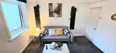 a living room with a couch and a window at Comfortable 3BR - Sleeps 5 - Fast WiFi -Parking in Barrow in Furness