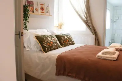 a bedroom with a bed with pillows and a window at #55 Spacious2BR End-Terrace in Kensington Sleeps 6 in Liverpool