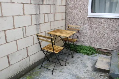 two chairs and a wooden table against a wall at #55 Spacious2BR End-Terrace in Kensington Sleeps 6 in Liverpool
