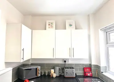a kitchen with white cabinets and a microwave at #55 Spacious2BR End-Terrace in Kensington Sleeps 6 in Liverpool