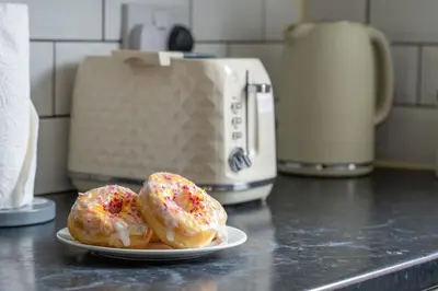 two donuts with sprinkles on a plate on a counter at #49 Luxury 4-Bedroom House with Modern Comforts in Liverpool