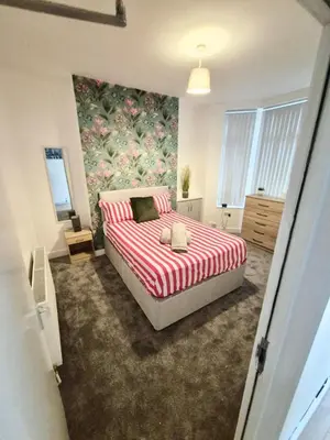 a bedroom with a bed with a red and white blanket at #49 Luxury 4-Bedroom House with Modern Comforts in Liverpool