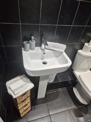 a bathroom with a white sink and a toilet at #49 Luxury 4-Bedroom House with Modern Comforts in Liverpool