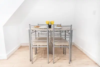 a glass table with chairs and a plate of food on it at #49 Luxury 4-Bedroom House with Modern Comforts in Liverpool