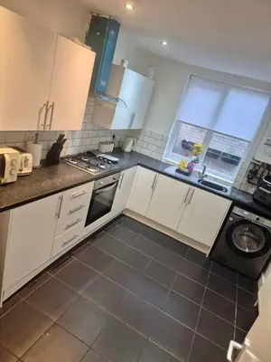 a kitchen with white cabinets and a stove top oven at #49 Luxury 4-Bedroom House with Modern Comforts in Liverpool