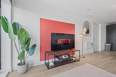a living room with a tv on a red wall at Liverpool City Stay 2BR Apartment Sleeps 3 in Liverpool