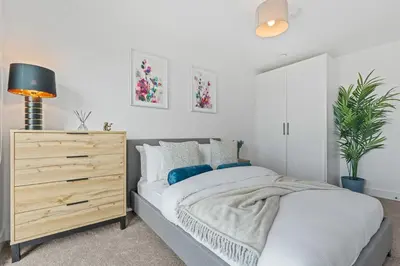 a white bedroom with a bed and a dresser at Liverpool City Stay 2BR Apartment Sleeps 3 in Liverpool