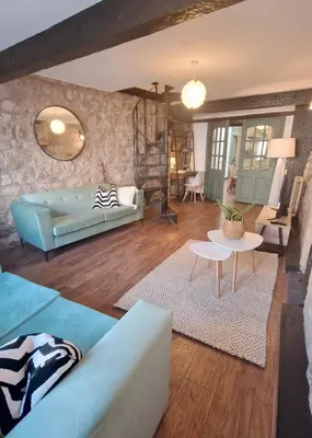 a living room with a couch and a table at Historic 1629 May Cottage with Hot Tub in Heysham
