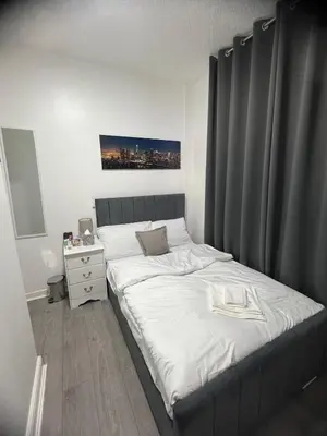 a bedroom with a large bed with a gray headboard at Desto lodge in liverpool in Liverpool