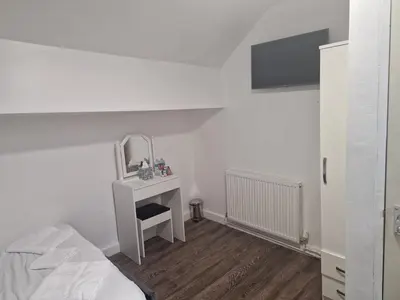 a bedroom with a bed and a dressing table with a mirror at Desto lodge in liverpool in Liverpool