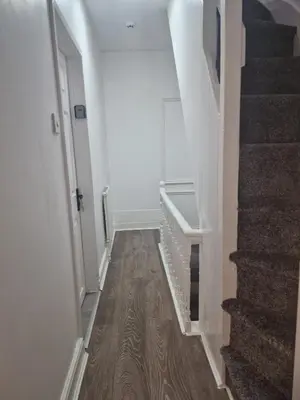 a hallway with a staircase with white walls and wood floors at Desto lodge in liverpool in Liverpool
