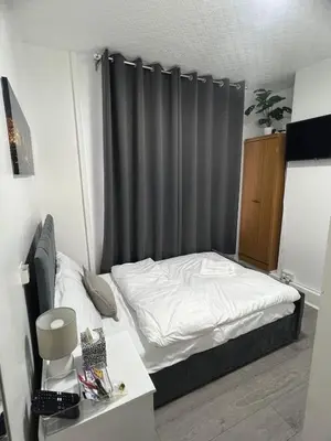 a bedroom with a bed with a gray curtain at Desto lodge in liverpool in Liverpool