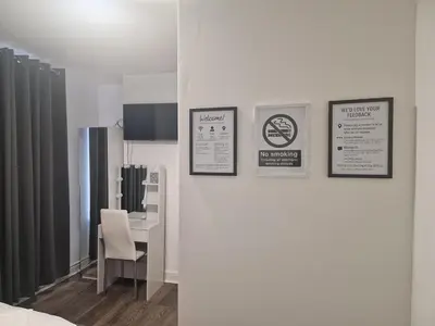a room with a bed and a table with a chair at Desto lodge in liverpool in Liverpool