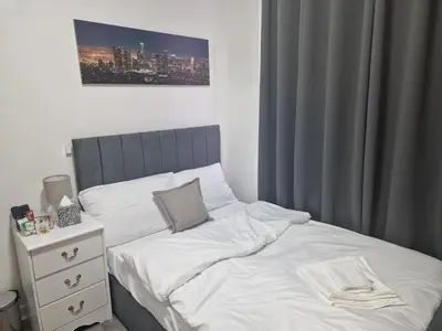 a bedroom with a white bed and a night stand at Desto lodge in liverpool in Liverpool