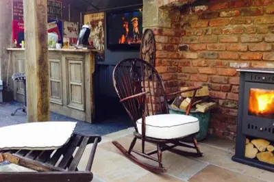 a room with two chairs and a fireplace at Fitzys Apartment Wellness Retreat
