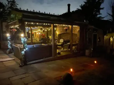 a conservatory at night with lights and a couch at Fitzys Apartment Wellness Retreat