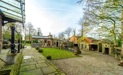 a backyard of a house with a garden and a building at Fitzys Apartment Wellness Retreat