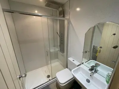 a bathroom with a shower and a sink and a toilet at Fitzys Apartment Wellness Retreat