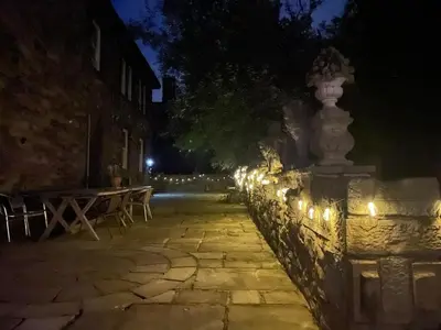 a stone wall with lights on it at night at Fitzys Coach House - Wellness Retreat
