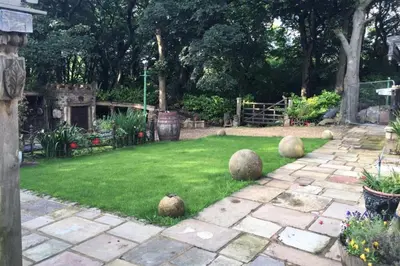 a garden with large balls on the grass at Fitzys Coach House - Wellness Retreat