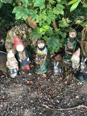a group of gnome statues in a garden at Fitzys Coach House - Wellness Retreat