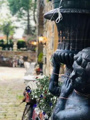 a statue of a girl holding a vase on a street at Fitzys Coach House - Wellness Retreat