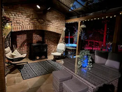 a living room with a fireplace and a brick wall at Fitzys Coach House - Wellness Retreat