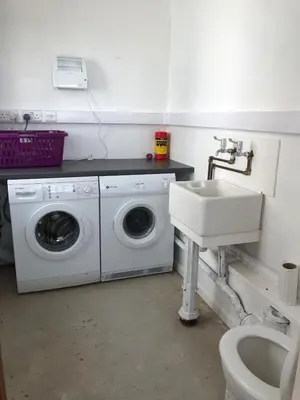 a bathroom with a washing machine and a sink at Fitzys Terrace Three Bed in Accrington