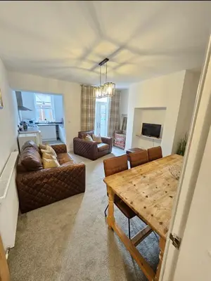 a living room with a table and a couch at Fitzys Terrace Three Bed in Accrington