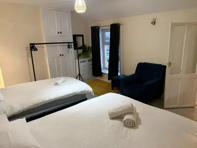 a bedroom with two beds and a blue chair at Oswaldtwistle Spacious 3 Bedroom Two Bath in Oswaldtwistle