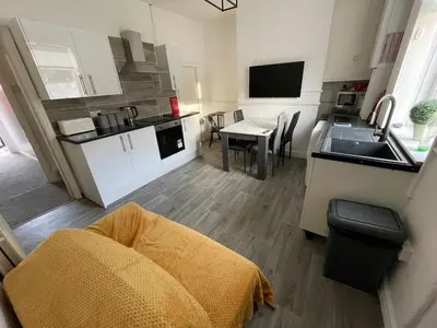 a small kitchen with a sink and a table at Accrington Three Bed in Accrington