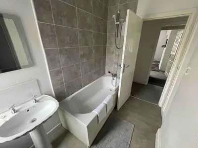 a bathroom with a sink and a tub and a toilet at Accrington Three Bed in Accrington