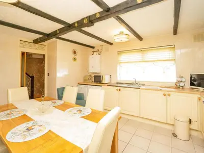 a kitchen with a wooden table with white chairs and a table and a table at Liverpool Rooms Near City & Stadiums in Liverpool