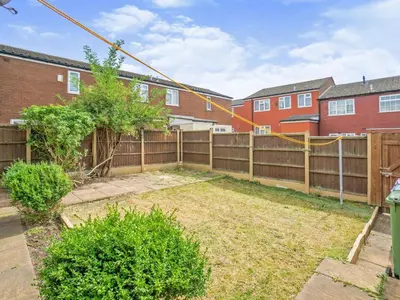 a backyard with a wooden fence and a yard with bushes at Liverpool Rooms Near City & Stadiums in Liverpool