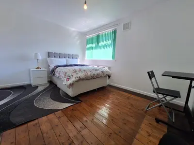 a bedroom with a bed and a desk and a window at Liverpool Rooms Near City & Stadiums in Liverpool