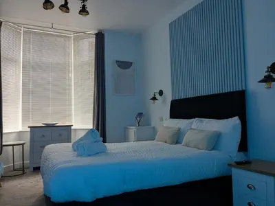 a blue bedroom with a bed with a teddy bear on it at Aurum House Luxury Apartments in Blackpool
