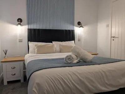 a child is laying on a bed in a bedroom at Aurum House Luxury Apartments in Blackpool