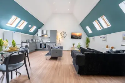 a living room with couches and a dining room at Belgrave Chapel - Luxurious Apartment in Darwen