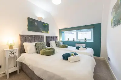 a bedroom with two beds with pillows on them at Belgrave Chapel - Luxurious Apartment in Darwen
