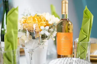 a bottle of wine next to a vase with flowers at Belgrave Chapel - Luxurious Apartment in Darwen