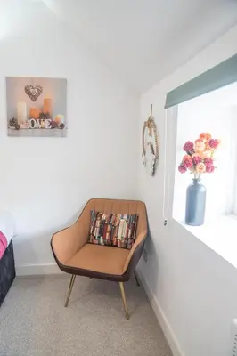 a chair sitting in a room with a window at Belgrave Chapel - Luxurious Apartment in Darwen
