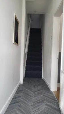 a hallway with a staircase with blue carpet at House4 holiday in Liverpool