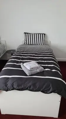 a black and white bed with a towel on it at House4 holiday in Liverpool