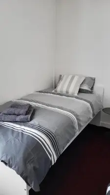 a bed in a white room with two pillows on it at House4 holiday in Liverpool