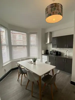 a kitchen and dining room with a table and chairs at Wadham Suites in Liverpool