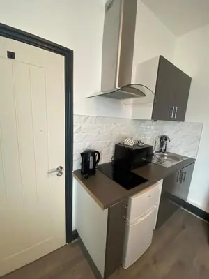 a kitchen with a sink and a counter top at Wadham Suites in Liverpool