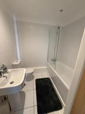 a white bathroom with a sink and a shower at Spacious City Centre 2 Bedroom Apartment in Liverpool