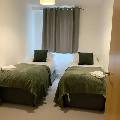 a room with two beds and a window at Spacious City Centre 2 Bedroom Apartment in Liverpool